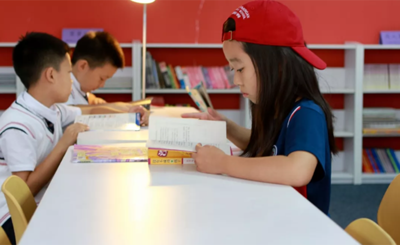 北京力迈中美国际学校_国际小学部学生在图书馆看书