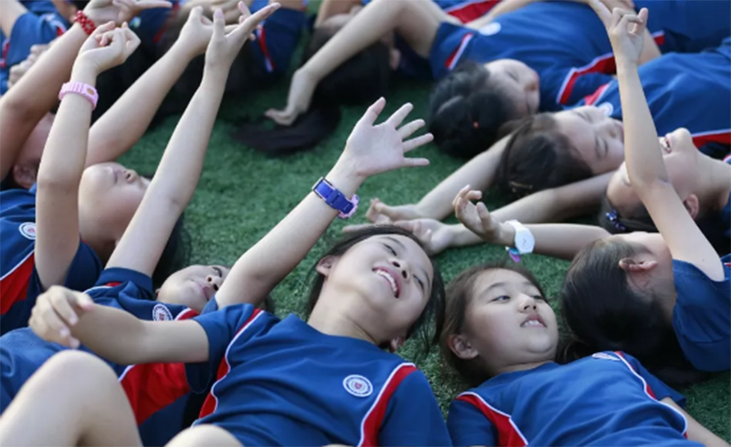 北京力迈中美国际学校_国际小学部学生躺在草坪上仰望蓝天