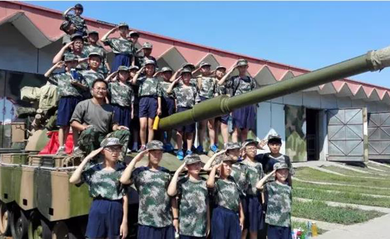 北京中合育才军旅特训营参观军营坦克的合影的学生