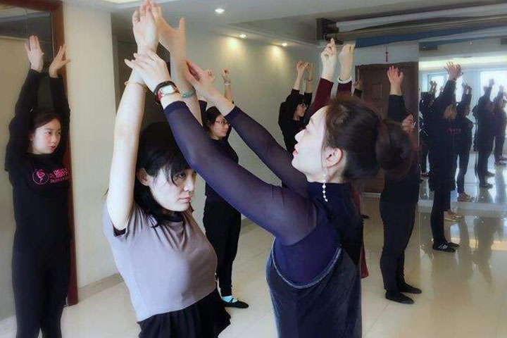 天津朵雅时尚礼仪培训老师在帮助学员纠正姿势