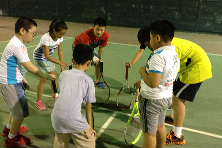 天津华夏聚龙网球俱乐部_老师在教孩子打网球