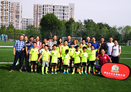 北京阳光乐贝足球俱乐部足球场上教练与学生合影