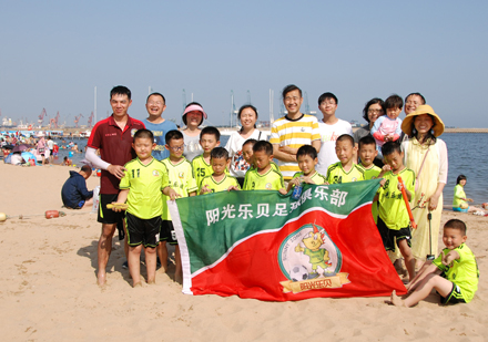 北京阳光乐贝足球俱乐部_沙滩上合影留念的学生